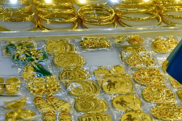 Người phụ nữ đang xem biểu đồ giá vàng trên điện thoại